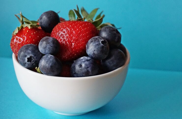 blueberries and strawberries in white ceramic bowl