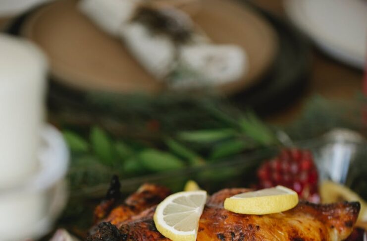 roasted chicken with vegetables in glass roaster on table with fir sprigs